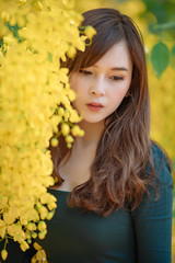 Naklejka premium Beautiful asian young woman outdoors in a forest. Pretty Thai girl in garden.
