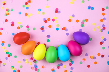 Colored Easter eggs on pink background. Flatlay.