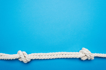 white long twisted ropes with sea knots isolated on blue