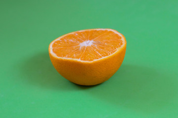 Sliced orange on green background