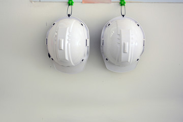 white safety hat hanging on wall at the factory