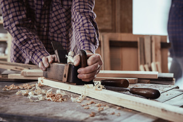 Carpenter or woodworker using an old plane