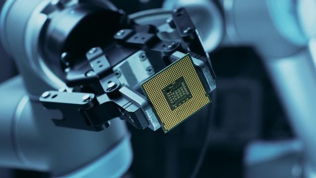 Modern High Tech Authentic Robot Arm Holding Contemporary Super Computer Processor Smoothly Moving into Focus