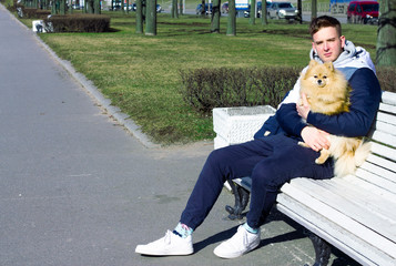 the guy in the park on the bench with his pomeranian spitz