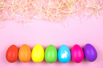 Colored Easter eggs on pink background. Flatlay.
