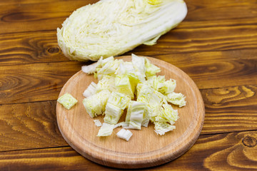 Chopped chinese cabbage on cutting board on wooden table