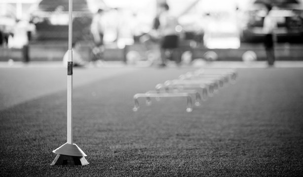 black and white image of hurdles and ladder drills on green artificial turf
