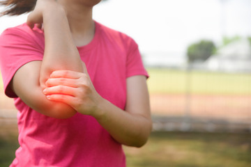 Woman suffering from arm pain, painful in arm muscles with red color highlight at arm. Health care and medical concept.