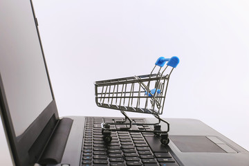 Shopping cart is on the laptop. Online sales concept.
