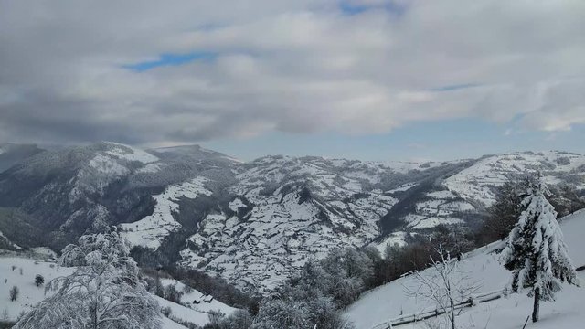 Paisaje de invierno en pueblo de Parva, Rumana Transilvania ramas de arbol cargados con nieve. monta&ntilde;as  de los C&aacute;rpatos cubierto de nieve 