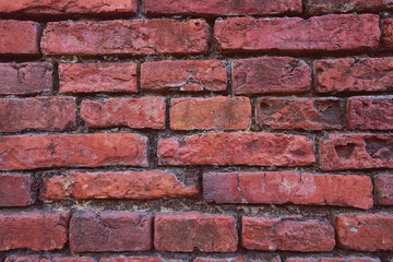 Red brick with cement in gap line in background.