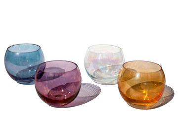 Four multicolored vintage round glasses on a white background with beautiful colored shadows in sunlight isolated close up