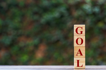 Stacked four wooden block with "GOAL" text Depicts targeting and achieving goals.