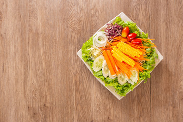  pasta salad with red cherry tomatoes, feta cheese, farfalle, arugula, baby spinach salad bowl on wooden table.