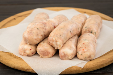 Fresh raw sausage on the wooden background