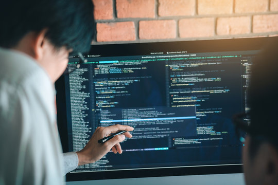 Developing programming and coding technology working in a software engineers developing applications together in office.