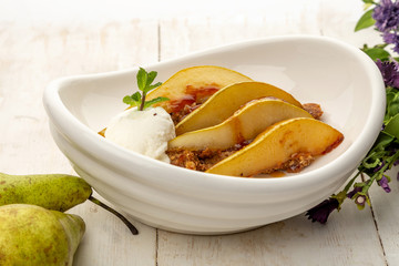 roasted pear in caramel on homemade hazelnut cookies and ice cream ball