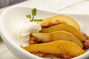roasted pear in caramel on homemade hazelnut cookies and ice cream ball