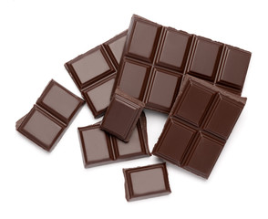 Dark organic chocolate pieces isolated on white background