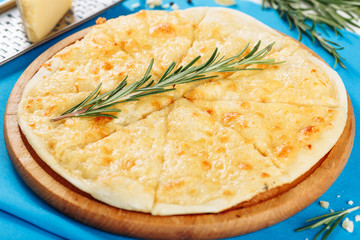 Four Cheese Pizza Served on Board Blue Background