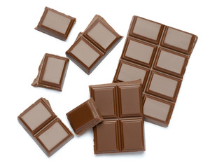 Milk organic chocolate pieces isolated on white background