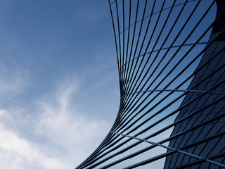 3D stimulate of high rise curve glass building and dark steel window system on blue clear sky...