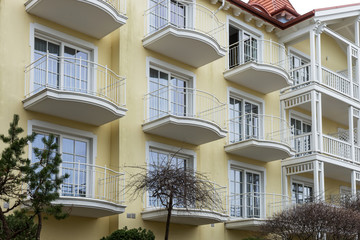 Fototapeta na wymiar Yellow facade with balconies on modern apartment house