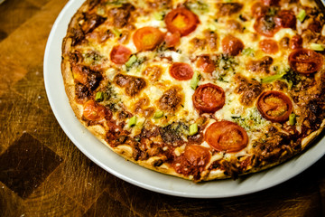 Homemade pizza baked as fast and healthy food on dark wooden table.