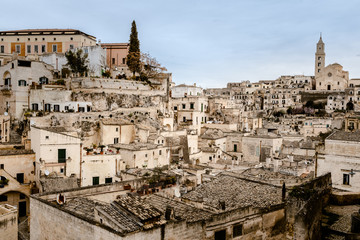 Fototapeta premium Panoramic view of the city of Matera in Italy, ancient curious village for tourists to be built inside the rocks in caves and stone houses, seen from the top.