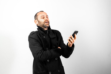 Middle-aged man laughing while talking on his mobile phone, isolated on white.