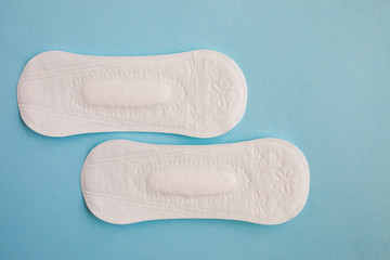 Feminine hygiene pad on a pink background. Concept of feminine hygiene during menstruation. Flat lay, top view.