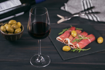 Black stone platter with slices of cured ham or Spanish jamon serrano or Italian prosciutto crudo