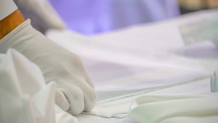 12902_Hands_with_white_gloves_folding_a_tablecloth.jpg