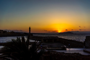 Panorama venetian harbour waterfront and Lighthouse in old harbour of Chania at sunset, Crete, Greece