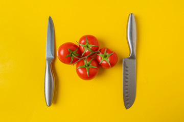 red vegetables and knives on yellow background