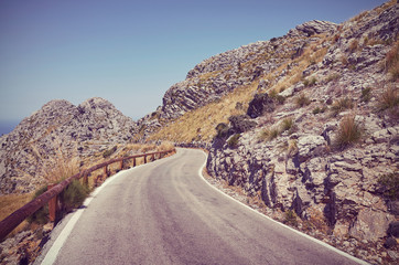 Retro toned picture of a scenic winding mountain road, Mallorca, Spain.
