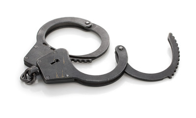 Pair of steel metal handcuffs isolated on white background.