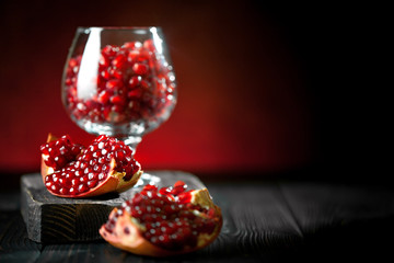 Ripe pomegranate fruit on a old black wooden vintage background. Background with copy space. Horizontal.