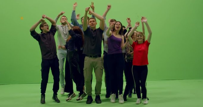 GREEN SCREEN CHROMA KEY Front view group of young people dancing and jumping with hands in the air. 4K UHD ProRes 4444