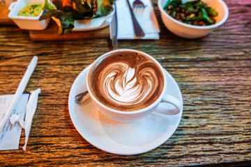 Hot latte art coffee on wood table