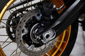 Disc brake with wheel hub on a motorcycle. Close up rear disc brake on a motorcycle. Car care and maintenance concepts. - Selective focus