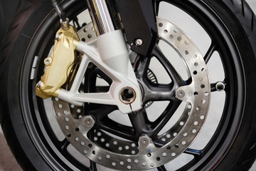Obraz na płótnie Canvas Disc brake with wheel hub on motorbike. Close up of front disc brake on motorcycle. Motorcycle car care and maintenance concepts. - Selective focus