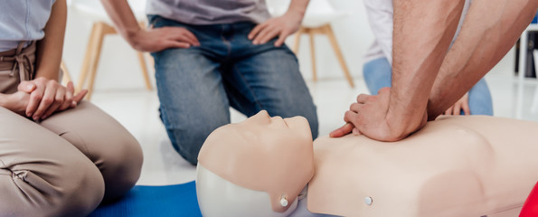 cropped view of man performing chest compression on dummy during cpr training class - obrazy, fototapety, plakaty