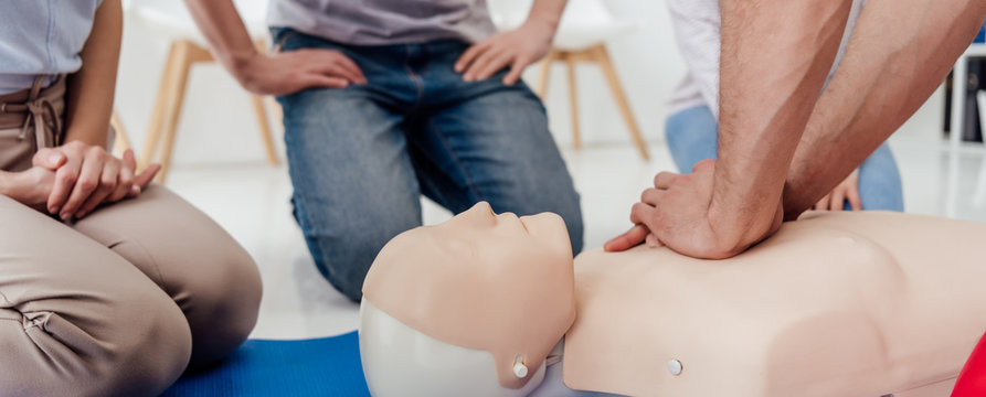 cropped view of man performing chest compression on dummy during cpr training class