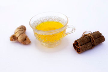 Popular turmeric tea isolated on white with its entire ingredients which are turmeric powder and raw, honey and cinnamon sticks.Used for detoxifying body.Isolated on white.