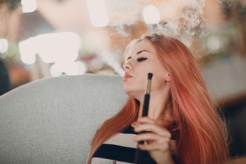 Fototapeta premium Young beautiful female smoking hookah. Smoke shisha hookah concept.