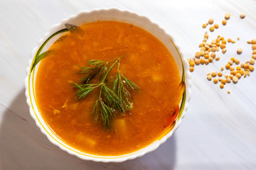 Veggie pea soup with carrots and dill on a white background