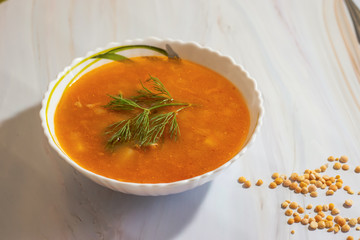 Veggie pea soup with carrots and dill on a white background