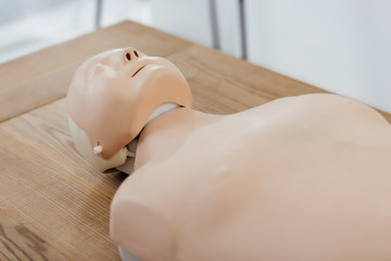 cpr dummy for first aid training on wooden table