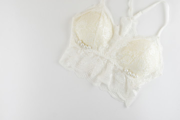 Lingerie series. White lingerie with pearls on white background.